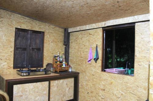 Zimmer mit einer Steinmauer und einem Fenster in der Unterkunft เฮือนกว่าง in Pua