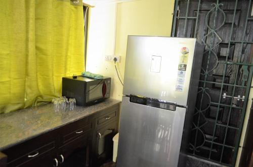 a kitchen with a stainless steel refrigerator and a microwave at Marias house in Siroda
