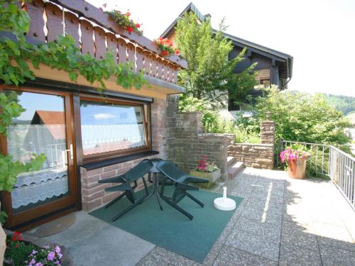 バイアースブロンにあるPanoramic view Apartment in Baiersbronn with Gardenの建物の隣にパティオ(ベンチ付)