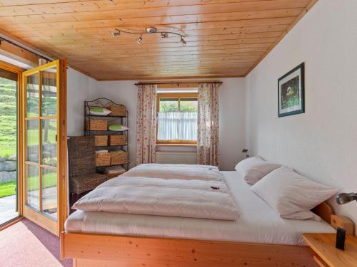 Cama grande en habitación con ventana en Apartment near the Halblech ski resort, en Trauchgau
