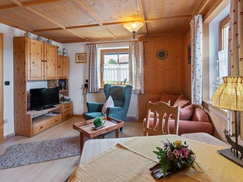 sala de estar con sofá y TV en Apartment near the Halblech ski resort, en Trauchgau