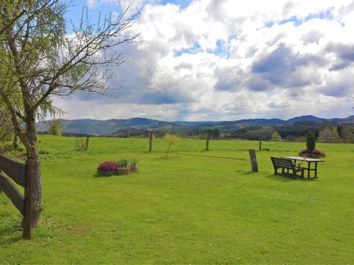 a park with a bench in a field with mountains in the background at Apartment with panoramic views in Attendorn
