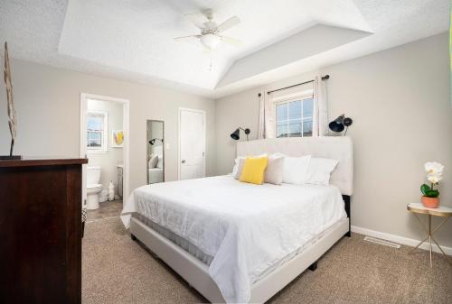 a white bedroom with a bed and a bathroom at 101 Karen Ct Conveniently Near Everything in Oak Grove
