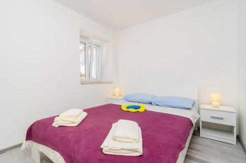 a white bedroom with a bed with towels on it at Apartment Jasmin in Dubrovnik