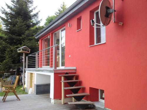 een rood huis met een trap aan de zijkant bij Bright holiday home in Schnett with private garden in Schnett