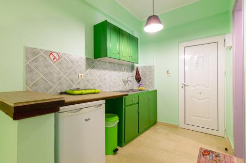 a green kitchen with green cabinets and a white door at Ni-Mar Studios & Apartments in Lithakia