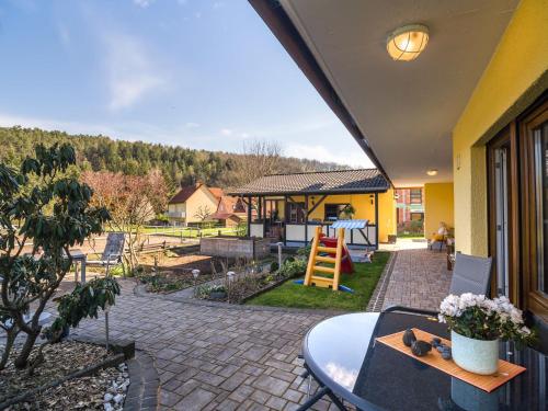 eine Terrasse mit einem Tisch und Blick auf einen Hof in der Unterkunft Apartment in the Odenwald with terrace in Mossautal