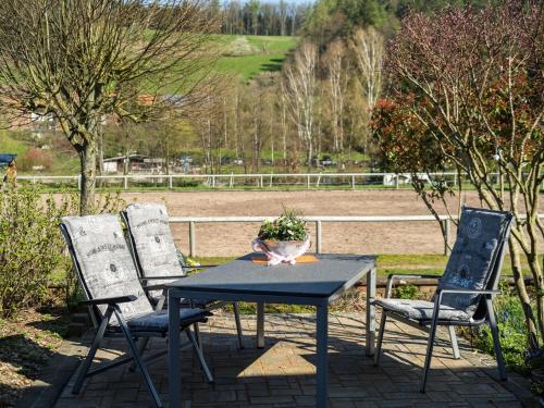 a table with two chairs and a vase on it at Apartment in the Odenwald with terrace in Mossautal