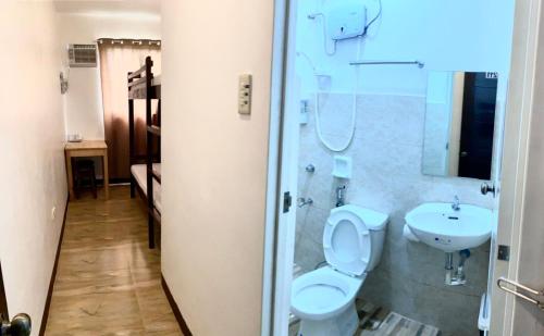 a bathroom with a toilet and a sink at Kampotel Davao in Davao City
