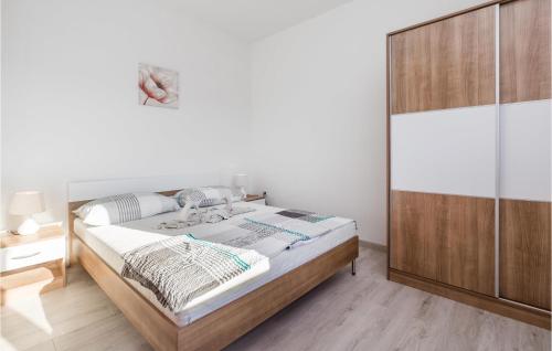 a bedroom with a bed and a wooden cabinet at Pet Friendly Apartment In Kampor With Kitchen in Kampor