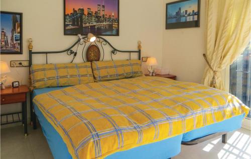 オリフエラ・コスタにあるCozy Home In Orihuela Costa With Kitchenetteのベッドルーム1室(黄色と青の毛布付きのベッド1台付)