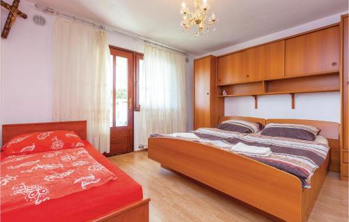 a bedroom with two beds and a chandelier at Stunning Apartment In Crikvenica With Wifi in Crikvenica