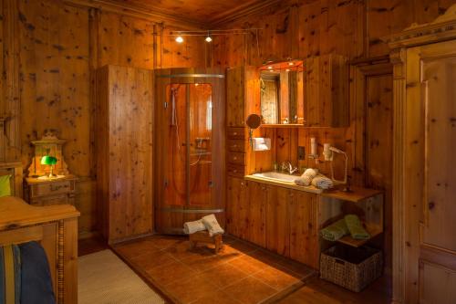 y baño de madera con ducha y lavamanos. en Saalhof Castle, en Maishofen