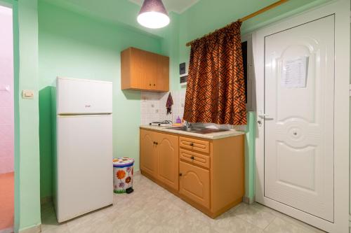a kitchen with a white refrigerator and a sink at Ni-Mar Studios & Apartments in Lithakia