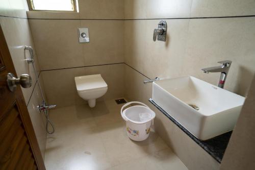 a small bathroom with a sink and a toilet at the woodland retreat in Dapoli