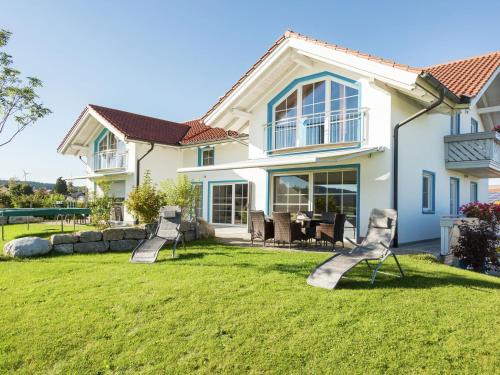 BernbeurenにあるAlluring Farmhouse in Ingenried with Solariumの庭に芝生の椅子が2脚ある家