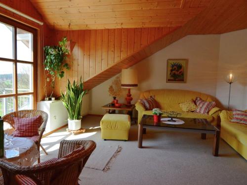 a living room with a couch and a table at Flat with sauna in the Bavarian Forest in Waldkirchen