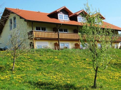ein Haus auf einem Hügel mit einem Blumenfeld in der Unterkunft Apartment in Rotthalm nster with Private Terrace Garden BBQ in Rotthalmünster