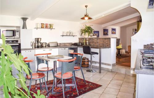 - une cuisine avec une table et quelques tabourets dans l'établissement 3 Bedroom Nice Home In Santec, à Santec