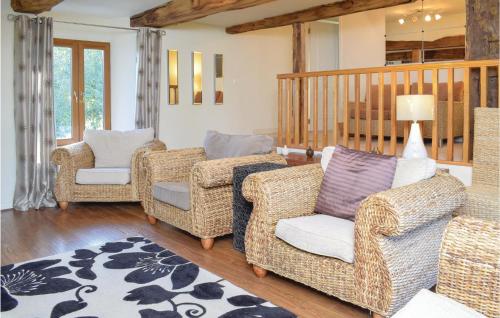 sala de estar con sillas de mimbre y alfombra en 3 Bedroom Gorgeous Home In Saint Manvieu Bocage en Saint-Manvieu-Bocage