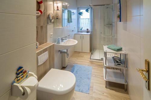 uma casa de banho com um WC, um lavatório e um chuveiro em Friesenstübchen em Dornumersiel