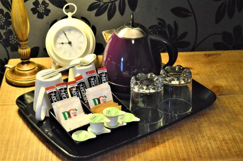 a tray with a tea set on a table with a clock at All Seasons Rest in Windermere