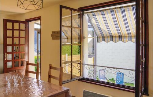 a dining room with a table and a window at Awesome Home In Hauteville-Sur-Mer in Hauteville-sur-Mer