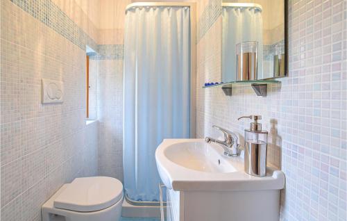uma casa de banho branca com um lavatório e um WC em Maso Weiss em Bieno