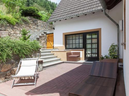 a patio with two chairs and a house at Beautiful Apartment in Merschbach with Garden in Merschbach