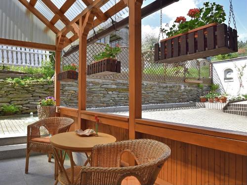 un patio con mesa, sillas y pérgola en Apartment in Thuringian Forest with garden en Oberweißbach