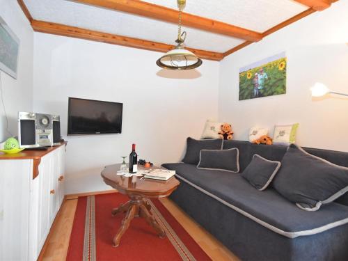 ein Wohnzimmer mit einem blauen Sofa und einem Tisch in der Unterkunft Attractive holiday home in Langewiesen with garden in Langewiesen