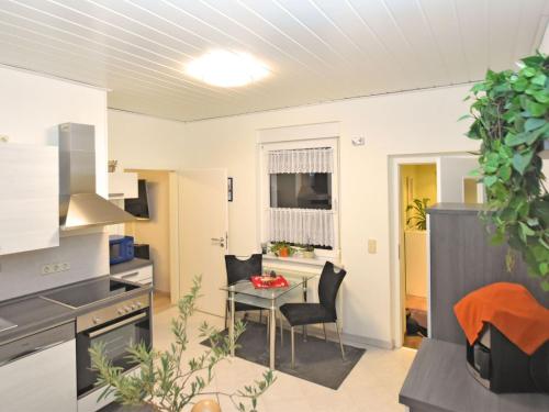 eine Küche und ein Wohnzimmer mit einem Tisch und Stühlen in der Unterkunft Cosy apartment in the Harz Mountains in Nordhausen