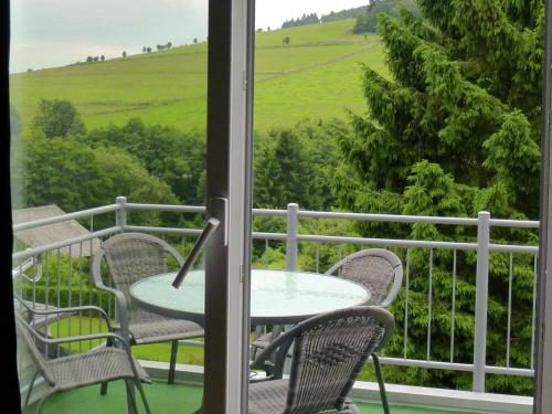 a table and chairs on a balcony with a view at Beautiful Apartment in Willingen with a Balcony in Willingen