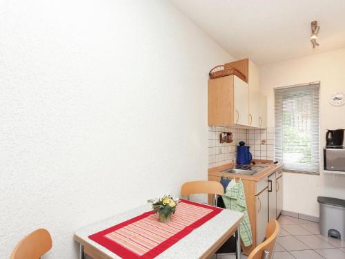 a kitchen with a table and chairs in a room at Holiday home with garden in Altenfeld