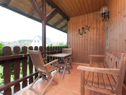 porche con sillas, mesa, mesa y sillas en Holiday home with garden, en Altenfeld