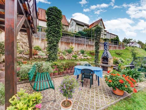 een patio met een tafel, stoelen en bloemen bij Holiday home with garden in Langenbach