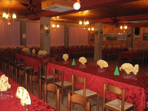 un salón de banquetes con mesas y sillas con mantel rojo en Hotel Casale, en Isola del Gran Sasso dʼItalia