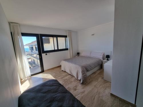 a bedroom with a bed and a large window at Apartamento Numi II in L'Ametlla de Mar