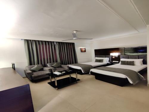a hotel room with two beds and a couch at The Samilton in Kolkata