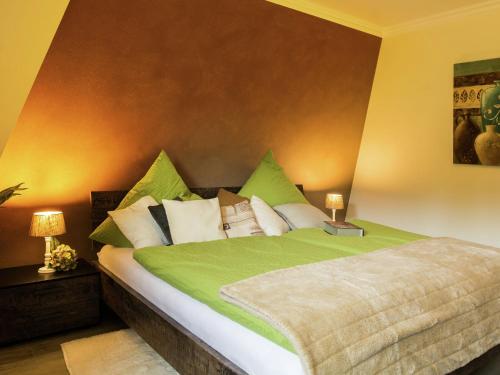 ヴィンターベルクにあるCozy Apartment In Winterberg Sauerland With Balconyのベッドルーム1室(緑と白の枕が備わるベッド1台付)