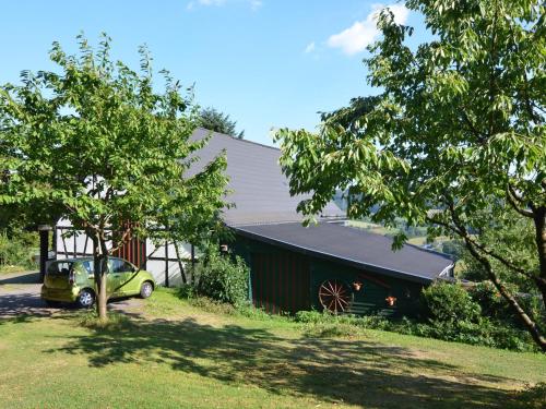 a green car parked in front of a barn at Quiet apartment in Sauerland with terrace in Schmallenberg