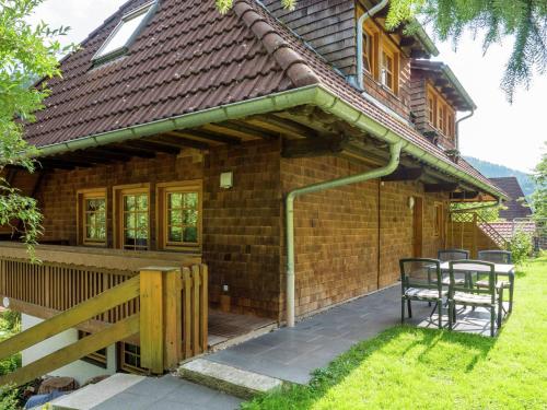 a wooden house with a deck and a table at Beautiful farmhouse near the ski area in Buchenbach