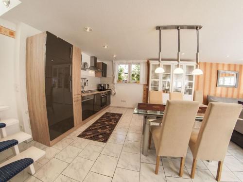 a kitchen and dining room with a table and chairs at Holiday home near forest in Fischbach in Emsetal