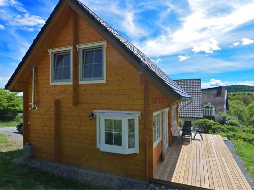 una pequeña casa de madera con terraza de madera en Home in Wissinghausen with Private Sauna, en Medebach