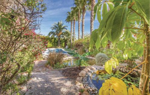 a garden with a swimming pool and palm trees at Urbanización Villamartín in Los Dolses