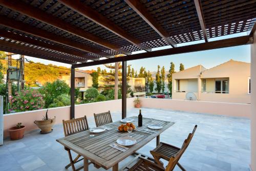 a wooden table and chairs on a patio at Elma's Dream Apartments & Villas in Kato Daratso