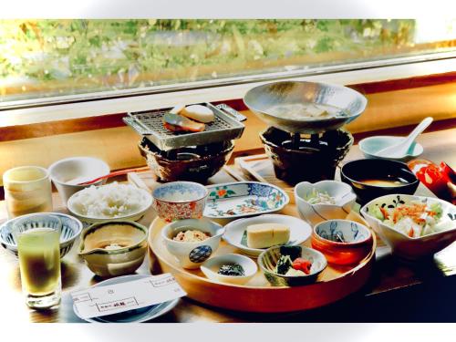 a table topped with bowls and plates of food at Ikyu in Ise