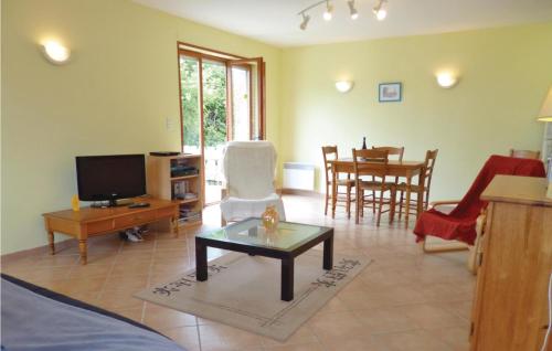 un salon avec une télévision et une table dans l'établissement 3 Bedroom Cozy Home In Brucheville, à Brucheville