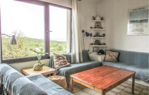 un salon avec un canapé, une table et une fenêtre dans l'établissement 3 Bedroom Nice Home In Porto Vecchio, à Perrelli