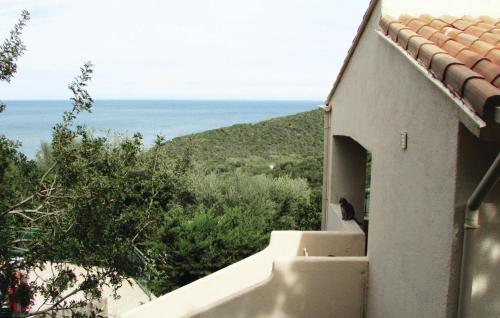 un oiseau assis sur la fenêtre d'un bâtiment avec l'océan dans l'établissement 3 Bedroom Nice Home In Porto Vecchio, à Perrelli
